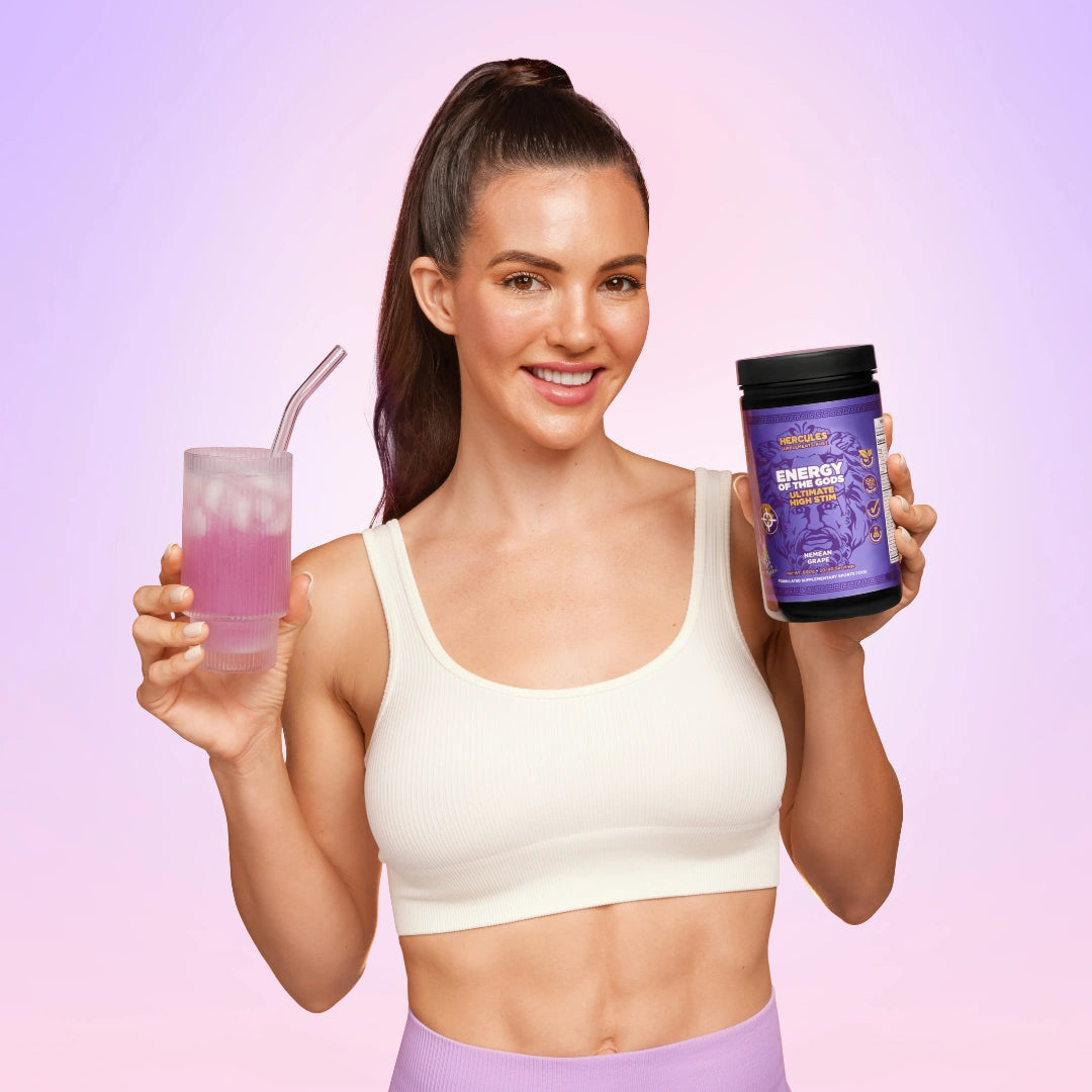 Woman holding a drink and a supplement container against a gradient pink background